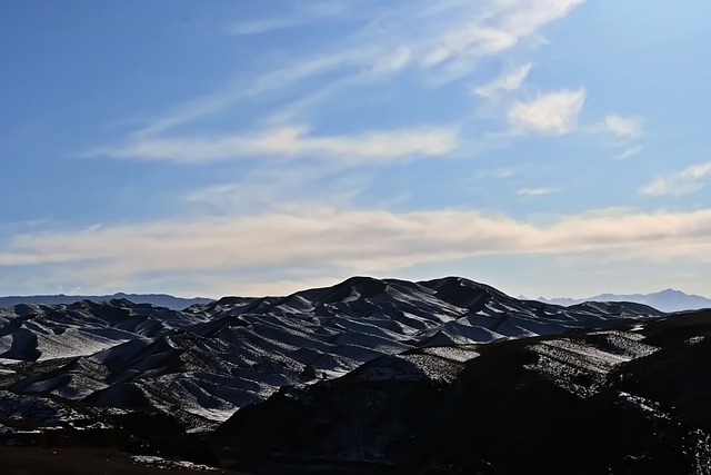雪后山巅的午后光影：冷光勾勒线条，雪面泛着淡蓝反光