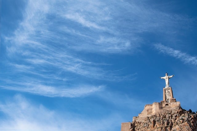 晴日云海漫过山峦 石拱旁的耶稣雕像静立观景台