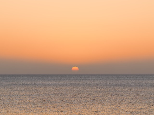 踩着潮润的近海细沙驻足，撞见海平线铺展的第一缕天光