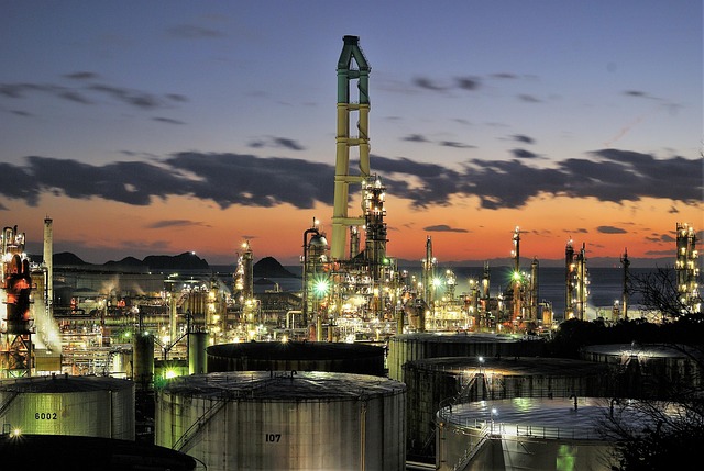 晚夏暮色漫过江畔厂区：熔金落日裹着车间烟火气